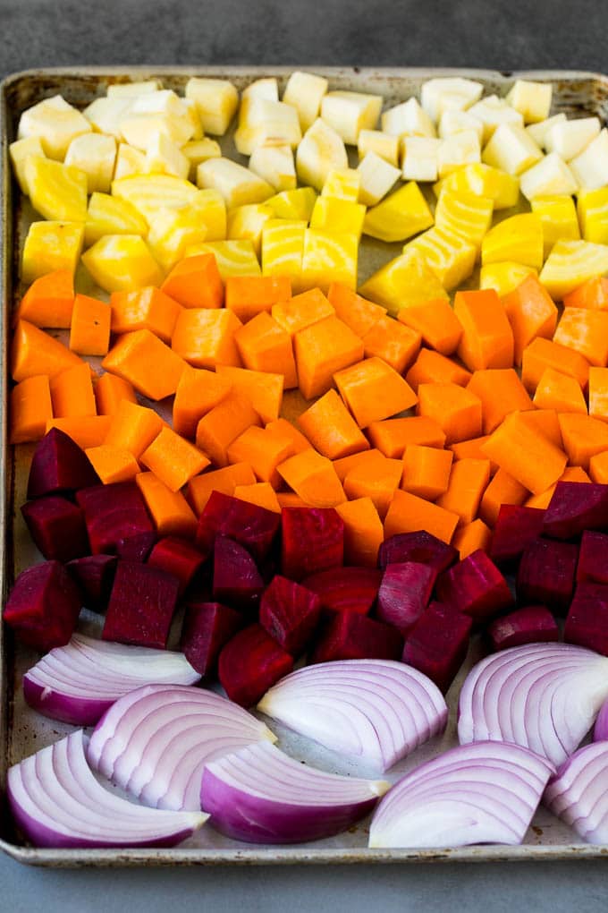 Roasted Root Vegetables Recipe | Roasted Sweet Potatoes | Roasted Beets | Roasted Carrots #carrots #beets #vegetables #sweetpotatoes #fall #parsnips #sidedish #edsug #cleaneating #healthy Onions, carrots, beets, parsnips and sweet potatoes on a sheet pan.