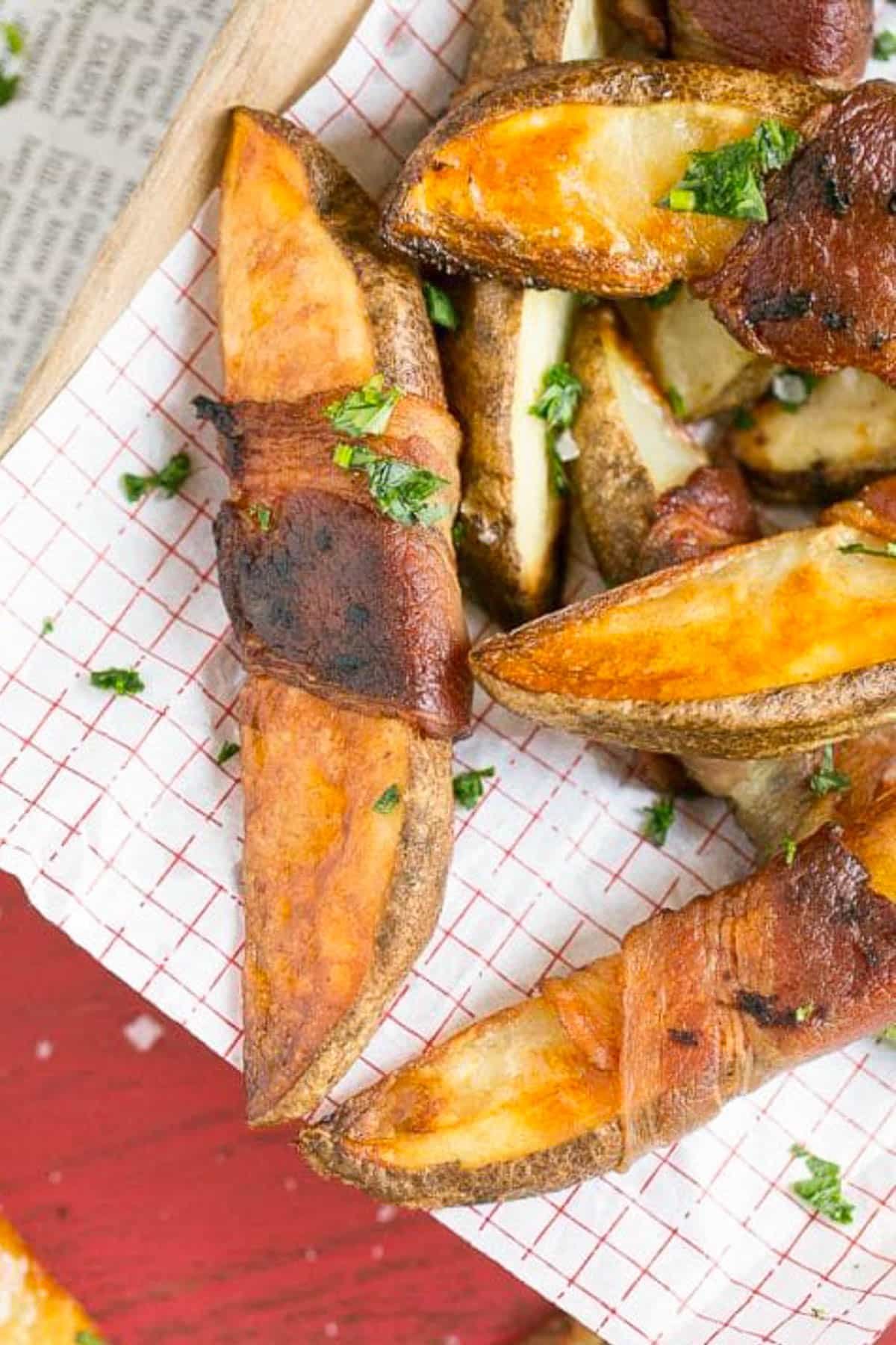 Bacon Wrapped Potato Wedges Recipe | Best Potato Wedges | Bacon Wrapped French Fries | Bacon Potato Wedges #bacon #potato #fries #dinner #edsug Bacon wrapped potatoes on a serving tray, topped with parsley.