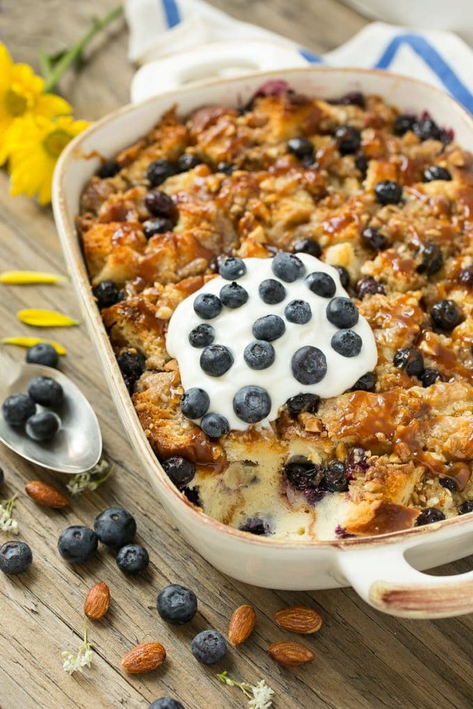 Blueberry Bread Pudding Recipe | Blueberry Bread Pudding | Easy Bread Pudding #blueberry #breadpudding #dessert #edsug A pan of blueberry bread pudding topped with streusel and caramel sauce.
