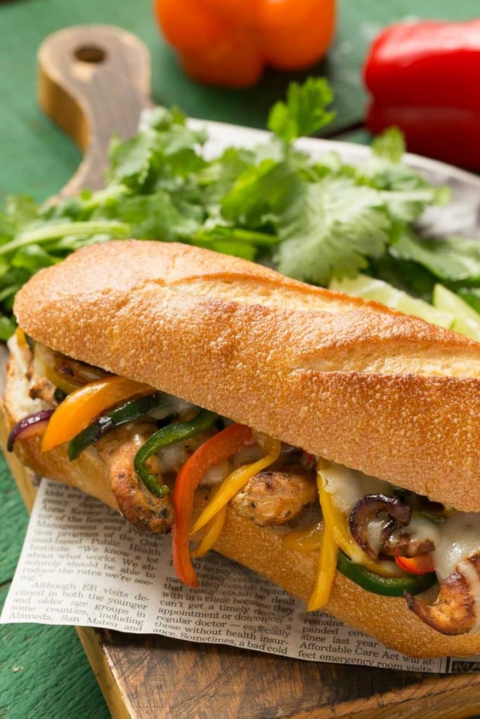 These fajita chicken cheesesteak sandwiches are full of spiced chicken, peppers and lots of cheese, all on a toasted roll.