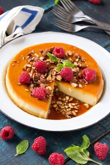 This rich and creamy flan is flavored with vanilla and almonds and is finished off with chopped honey roasted almonds and raspberries. #ad