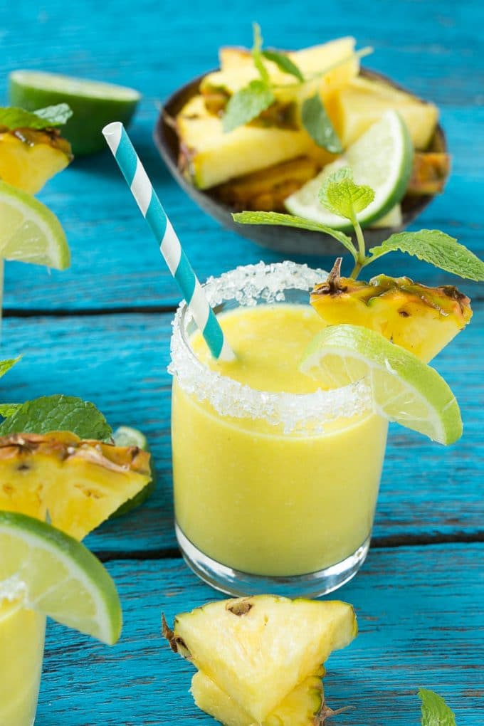 Pineapple Coconut Smoothie Recipe |Tropical Smoothie | Pineapple Smoothie #smoothie #pineapple #coconut #healthy #cleaneating #edsug A tropical smoothie with a paper straw in it.