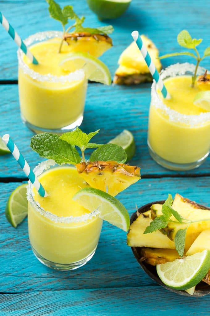Pineapple Coconut Smoothie Recipe |Tropical Smoothie | Pineapple Smoothie #smoothie #pineapple #coconut #healthy #cleaneating #edsug Pineapple coconut smoothies in glasses with sugared rims.