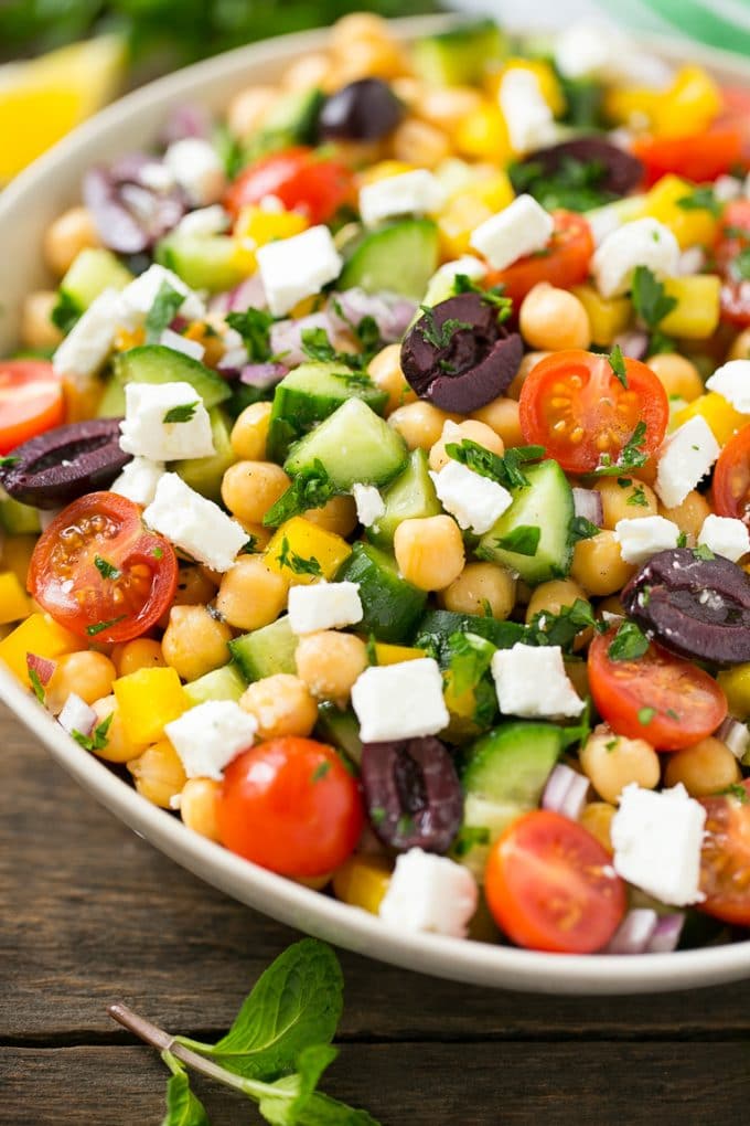 Greek Salad | Chopped Greek salad | Chopped Salad #salad #vegetarian #cheese #chickpeas #lunch #edsug Cucumbers, chickpeas, olives, tomatoes, peppers and feta cheese in a serving bowl.