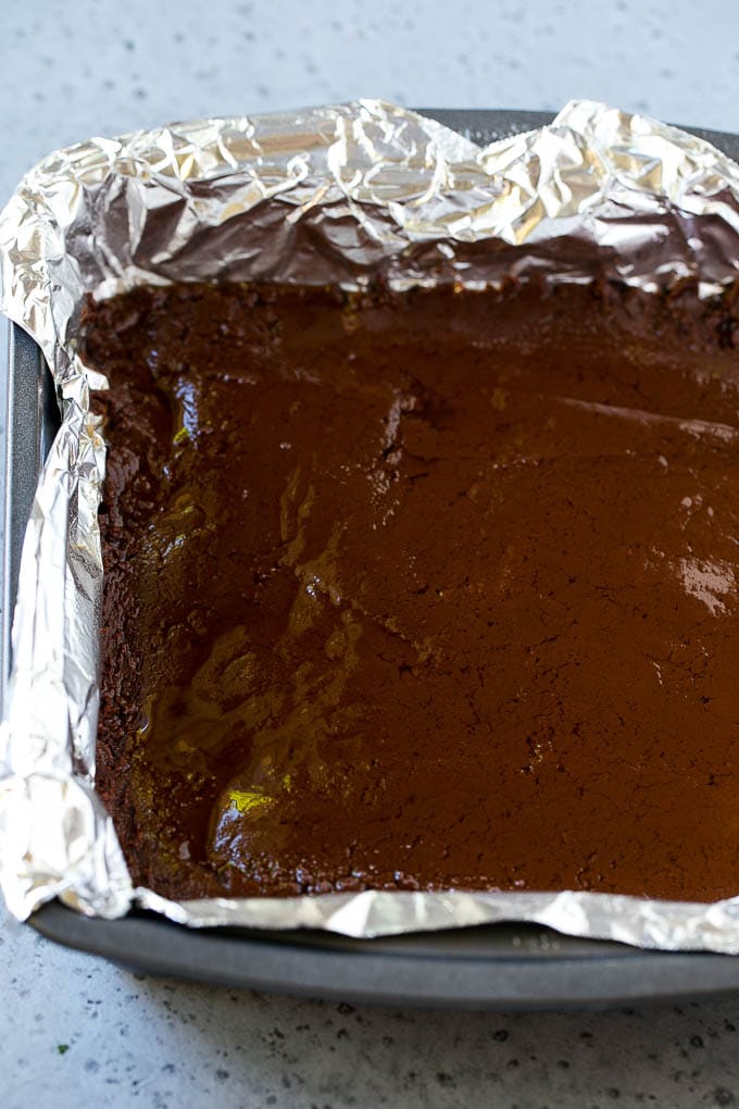 Chocolate Peanut Butter Fudge Recipe | Peanut Butter Cup Fudge | Easy Fudge Recipe #chocolate #peanutbutter #fudge #baking #dessert #edsug A layer of chocolate fudge in a pan.