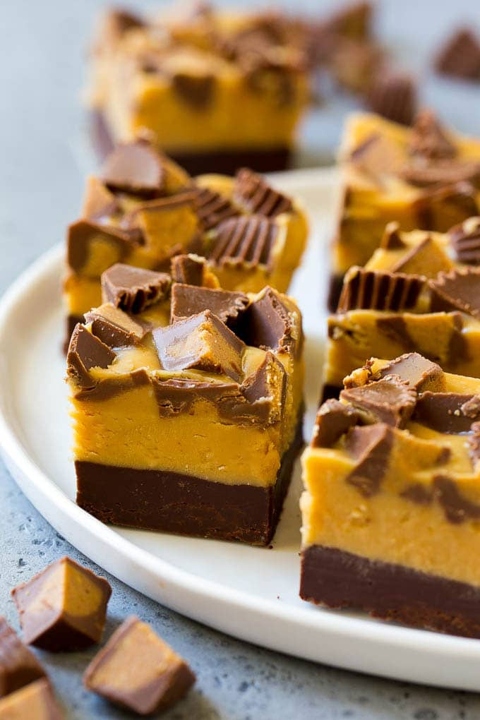 Chocolate Peanut Butter Fudge Recipe | Peanut Butter Cup Fudge | Easy Fudge Recipe #chocolate #peanutbutter #fudge #baking #dessert #edsug Squares of chocolate peanut butter fudge topped with peanut butter cups.