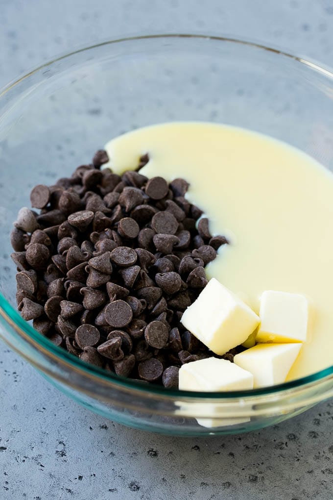 Chocolate Peanut Butter Fudge Recipe | Peanut Butter Cup Fudge | Easy Fudge Recipe #chocolate #peanutbutter #fudge #baking #dessert #edsug Chocolate chips, condensed milk and butter in a mixing bowl.