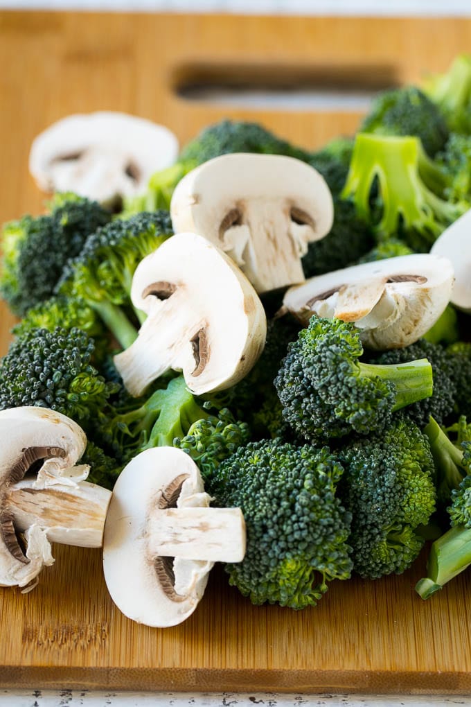 Chicken and Broccoli Stir Fry Recipe | Chicken Stir Fry | Healthy Chicken Recipe | Chicken and Broccoli | Chinese Food #chicken #broccoli #stirfry #healthy #cleaneating #dinner #edsug Broccoli florets and sliced mushrooms on a cutting board.