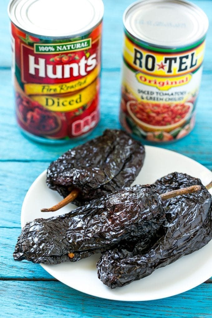 Cans of tomatoes and dried chiles on a plate.