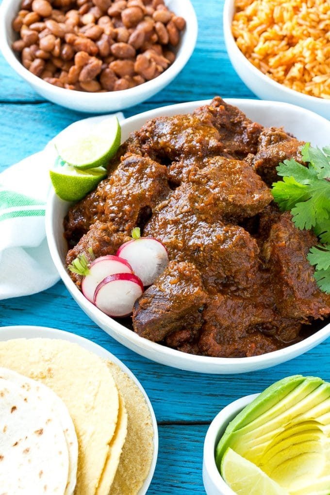Mexican stewed beef served with bowls of rice and beans.