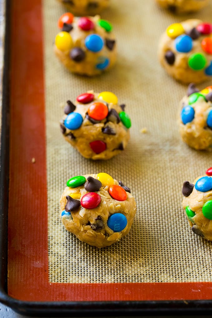 Monster Cookies Recipe | Oatmeal Cookies | Peanut Butter Cookies | M&M's Cookies #baking #cookies #dessert #peanutbutter #chocolate #edsug Balls of cookie dough on a baking sheet.