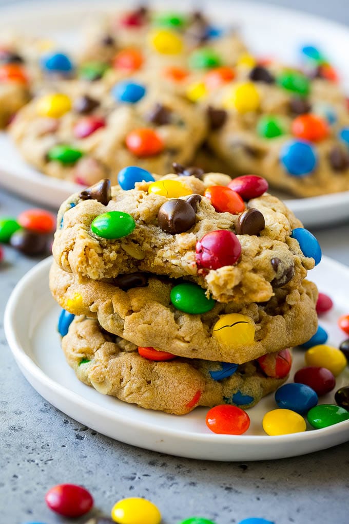 Monster Cookies Recipe | Oatmeal Cookies | Peanut Butter Cookies | M&M's Cookies #baking #cookies #dessert #peanutbutter #chocolate #edsug A stack of monster cookies with a bite taken out of one.