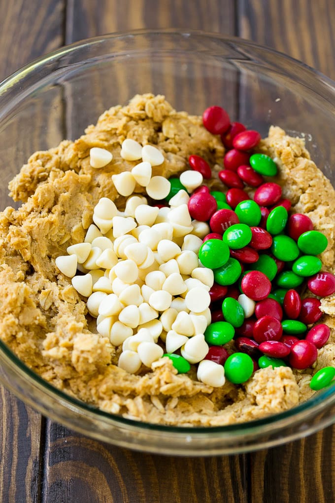 Christmas Monster Cookies Recipe | Oatmeal Cookies | Peanut Butter Cookies | M&M's Cookies #baking #cookies #dessert #peanutbutter #chocolate #edsug #christmas #sprinkles Cookie dough with red and green M&M's and white chocolate chips.