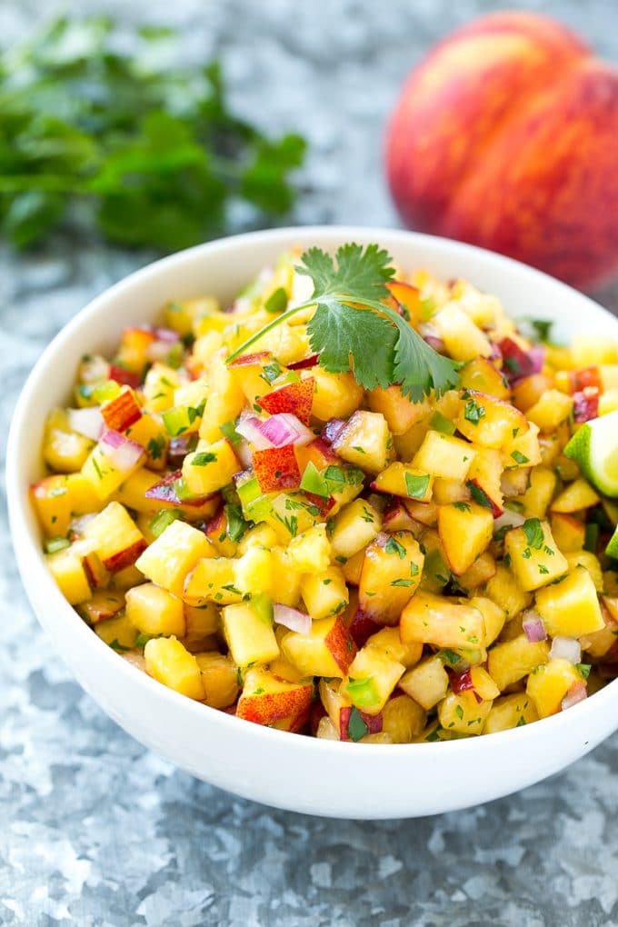 Peach Salsa | Fruit Salsa #peaches #salsa #dip #appetizer #edsug Peach salsa in a bowl made with red onion, jalapeno and cilantro.