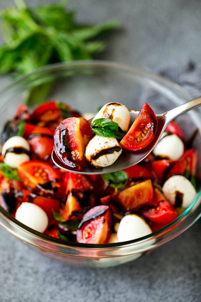 Caprese Salad Recipe | Tomato Salad #salad #tomato #mozzarella #cheese #basil #caprese #summer #edsug A serving spoon of caprese salad with tomato, mozzarella and basil.