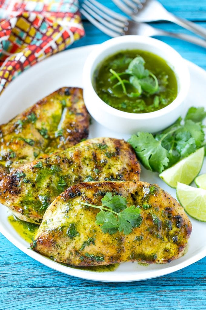 Cilantro Lime Chicken | Grilled Chicken #chicken #grilling #cilantro #lime #dinner #edsug Cilantro lime chicken topped with sauce and served with lime wedges.