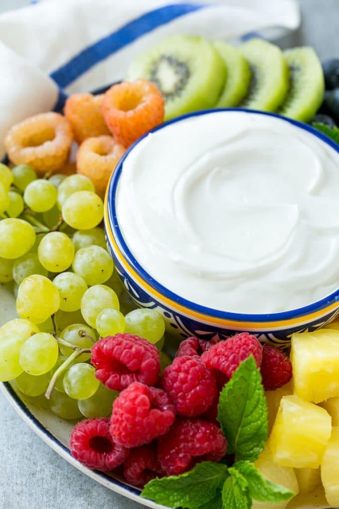 Cream Cheese Fruit Dip | Fruit Recipe | Fruit Dip #fruit #dip #creamcheese #snack #dessert #edsug A bowl of cream cheese fruit dip surrounded by grapes, raspberries and kiwis.