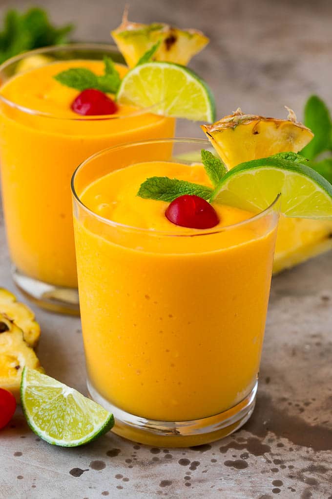 Tropical Smoothie Recipe | Mango Smoothie | Pineapple Smoothie #smoothie #mango #pineapple #banana #drink #edsug Two tropical smoothies with fresh mint, lime wedges and sliced pineapple.
