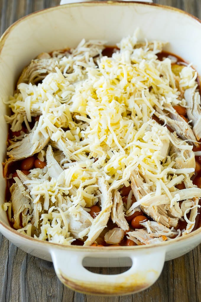 Chicken Enchilada Casserole Recipe | Chicken Enchiladas | Easy Casserole Recipe | Enchilada Casserole #chicken #casserole #enchiladas #cheese #beans #dinner #edsug Chicken, beans and shredded cheeses in a casserole dish.