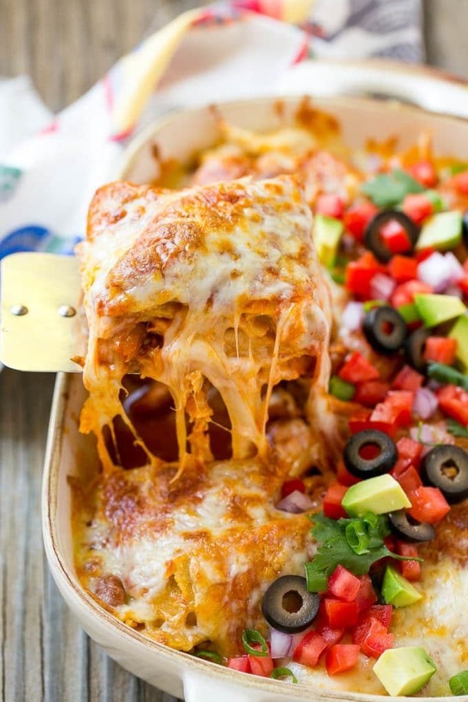 Chicken Enchilada Casserole Recipe | Chicken Enchiladas | Easy Casserole Recipe | Enchilada Casserole #chicken #casserole #enchiladas #cheese #beans #dinner #edsug A spatula serving up a portion of cheesy chicken enchilada casserole.