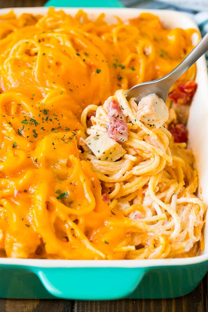 Chicken Spaghetti Recipe | Baked Spaghetti #pasta #spaghetti #chicken #cheese #casserole #dinner #edsug A fork serving up a portion of creamy chicken spaghetti.