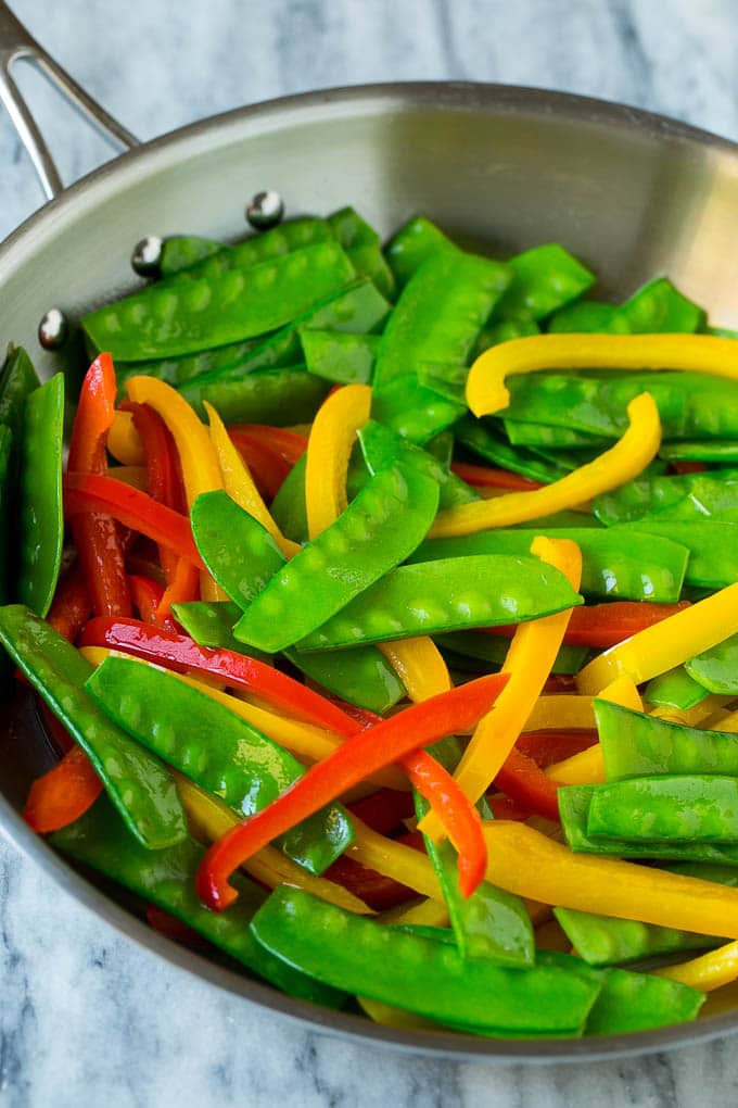 Teriyaki Shrimp Stir Fry Recipe | Shrimp Stir Fry | Healthy Stir Fry #shrimp #teriyaki #vegetables #stirfry #dinner #edsug Cooked snow peas and bell peppers in a skillet.