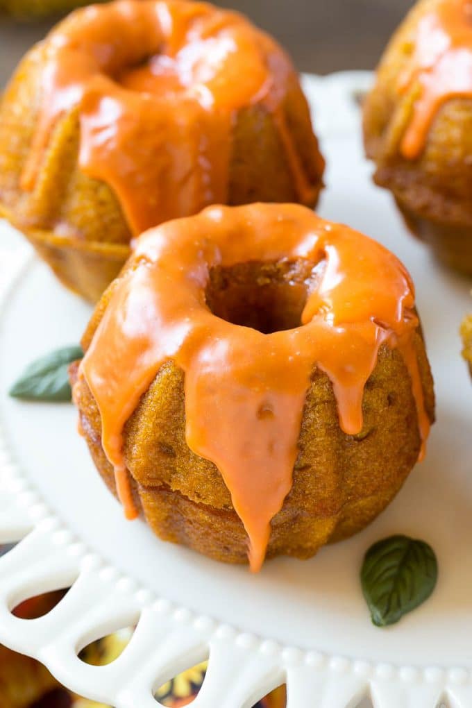 Pumpkin Spice Cake Recipe | Pumpkin Cake | Easy Pumpkin Cake | Thanksgiving Dessert #thanksgiving #pumpkin #cake #pumpkincake #spicecake #dessert #edsug #holiday Two bundt cakes stacked together with orange colored ganache on top.