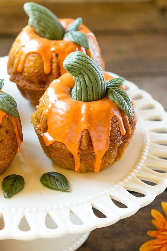 Pumpkin Spice Cake Recipe | Pumpkin Cake | Easy Pumpkin Cake | Thanksgiving Dessert #thanksgiving #pumpkin #cake #pumpkincake #spicecake #dessert #edsug #holiday A platter of pumpkin spice cakes decorated like pumpkins.