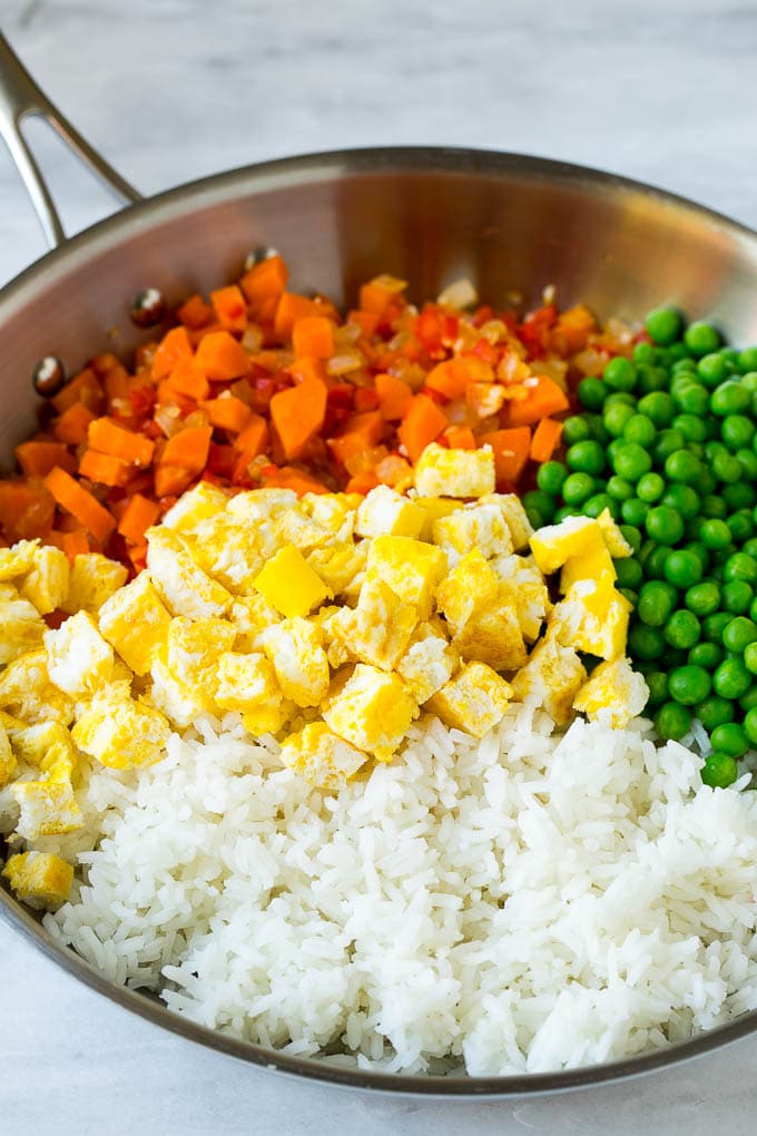 Veggie Fried Rice Recipe | Vegetarian Fried Rice #rice #friedrice #vegetarian #dinner #edsug #sidedish Vegetables, scrambled egg, rice and peas in a frying pan.