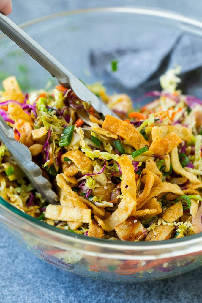 Chinese Chicken Salad Recipe | Asian Chicken Salad #salad #chicken #chickensalad #cabbage #lunch #dinner #edsug Tongs serving up a portion of Asian chicken salad.