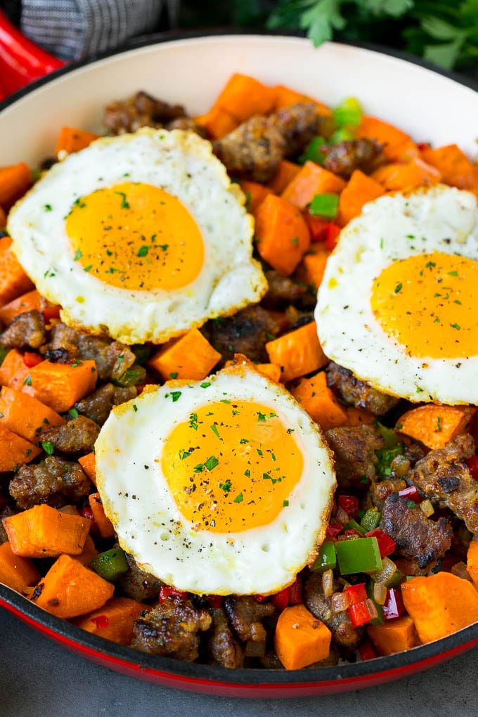 Sweet Potato Hash #sweetpotato #sausage #breakfast #brunch #edsug A pan of sweet potato hash topped with fried eggs.