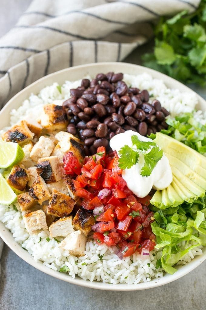 Burrito bowls with rice, chicken, salsa, beans and avocado.