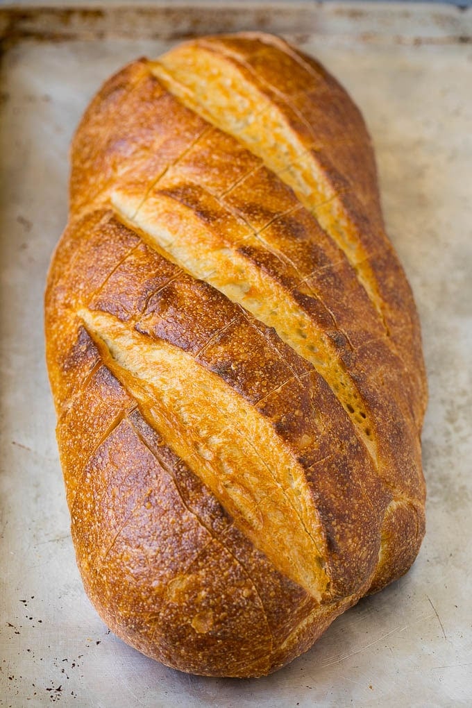 Pull Apart Bread | Garlic Bread | Cheese Bread #bread #garlic #cheese #sidedish #appetizer #edsug A loaf of bread on a sheet pan with diagonal cuts in it.