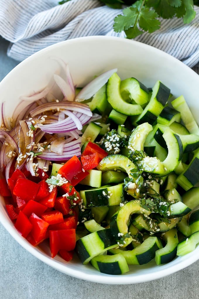 Asian Cucumber Salad Recipe | Sesame Cucumber Salad | Cucumber Salad | Healthy Salad | Healthy Cucumber Recipe #cucumber #cucumbersalad #salad #sidedish #edsug Sliced cucumbers, red peppers and onions with dressing.