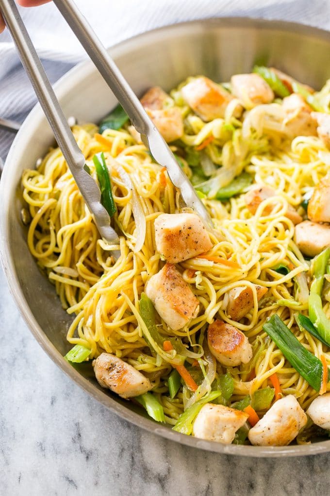 Chicken Chow Mein Recipe | Easy Chicken Recipe | Chow Mein | Chinese Food #chowmein #takeout #asianfood #edsug A pan of chicken chow mein with tongs pulling out a serving.