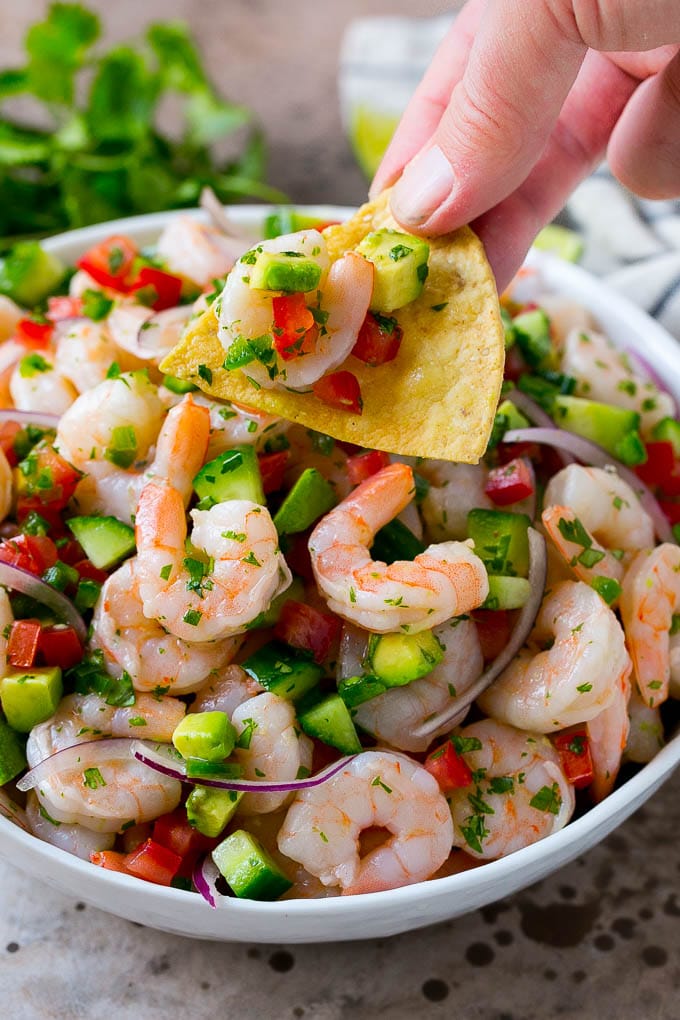 Shrimp Ceviche Recipe | Mexican Shrimp | Marinated Shrimp #shrimp #ceviche #cleaneating #healthy #lowcarb #keto #glutenfree #dinner #appetizer #edsug A bowl of shrimp ceviche with a tortilla chip scooping some out.