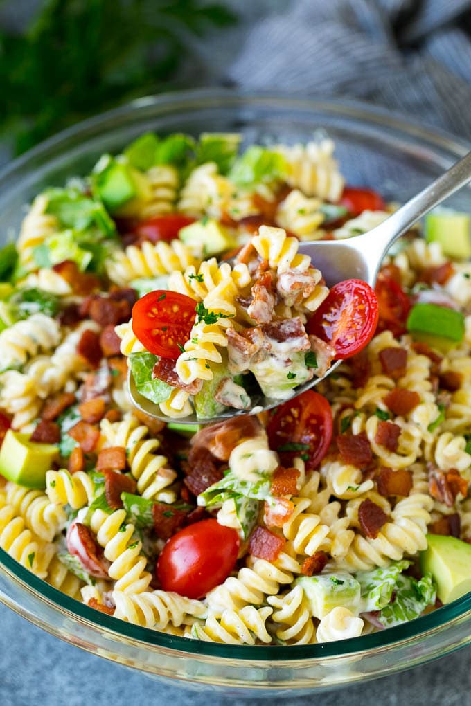 BLT Pasta Salad Recipe | Easy Pasta Salad | Bacon Pasta Salad #salad #pasta #blt #bacon #avocado #dinner #edsug A serving spoon filled with BLT pasta salad.