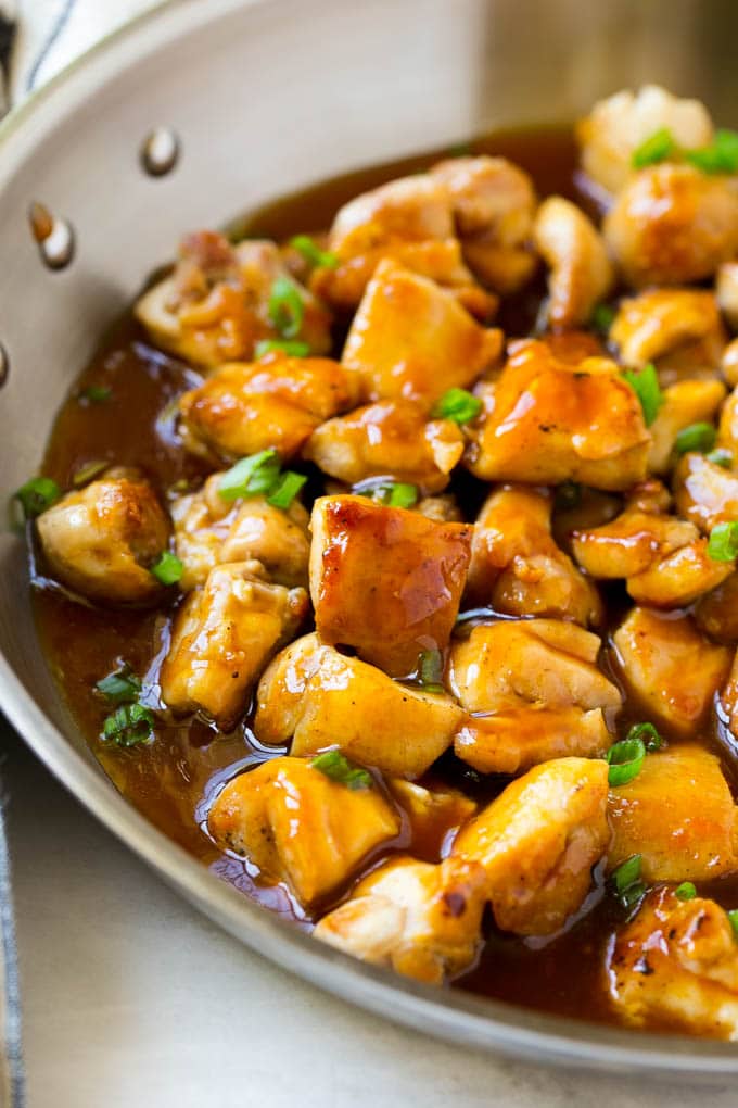 Bourbon Chicken | Sauteed Chicken | Chicken Stir Fry | Easy Chicken Recipe #chicken #dinner #edsug Bourbon chicken in a skillet coated in sauce and topped with green onions.