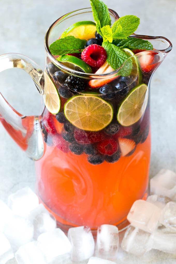 Berry Champagne Punch Recipe | Champagne Cocktail | Lime Cocktail | Berry Punch | Champagne Recipe #champagne #punch #berries #drink #edsug A pitcher of a cocktail garnished with fruit and mint.