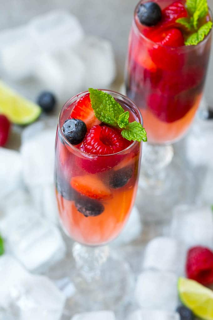 Berry Champagne Punch Recipe | Champagne Cocktail | Lime Cocktail | Berry Punch | Champagne Recipe #champagne #punch #berries #drink #edsug Two glasses of refreshing champagne punch with berries and mint on top.