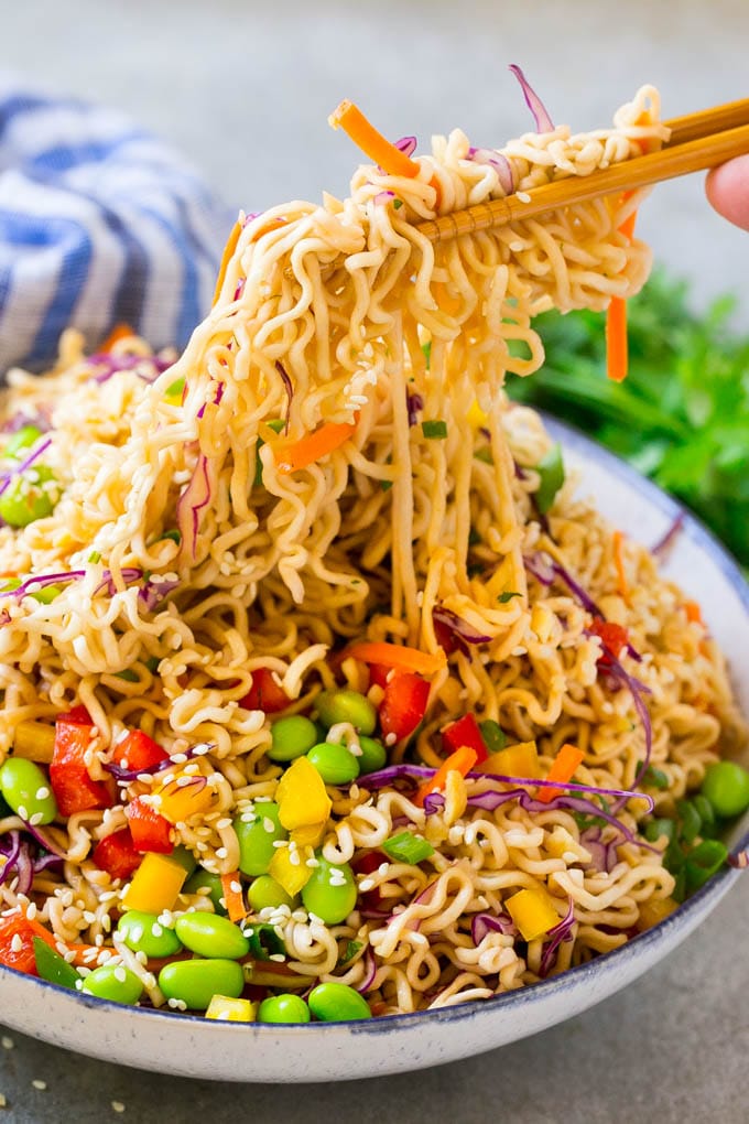 Asian Noodle Salad Recipe | Ramen Noodle Salad | Asian Salad #salad #noodles #edamame #vegetarian #edsug #lunch Chopsticks picking up noodles in a vegetable salad.