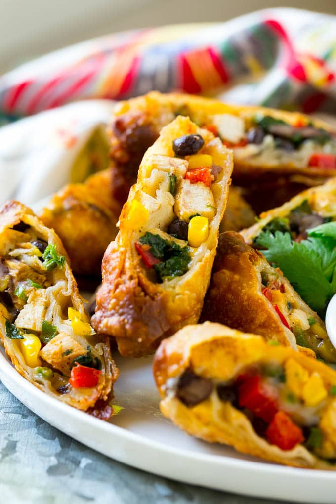 Southwestern Egg Rolls Recipe | Easy Egg Roll Recipe | Mexican Appetizer | Egg Roll Recipe | Southwest Egg Rolls #eggrolls #appetizer #chicken #snack #edsug Chicken egg rolls with colorful vegetables, cut and served with avocado ranch sauce.