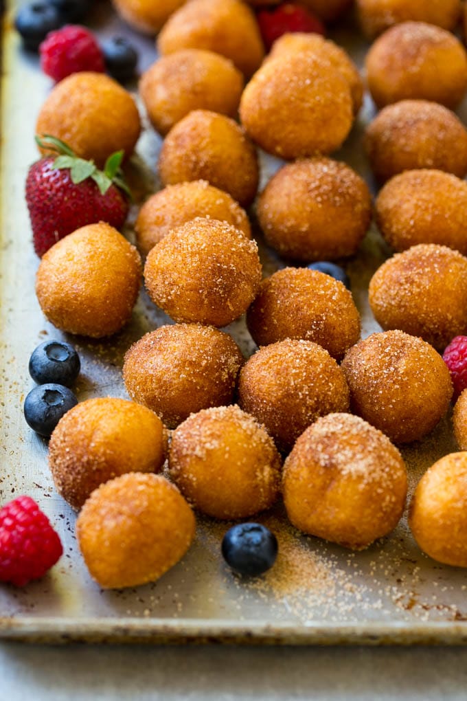Donut Bread Pudding Recipe | Easy Bread Pudding | Cinnamon Donuts | Make Ahead Breakfast Recipe #breadpudding #donuts #donutholes #breakfast #edsug Cinnamon sugar donut holes on a tray surrounded by berries