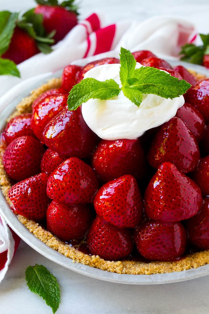 No Bake Strawberry Pie Recipe | Fresh Strawberry Pie | Strawberry Pie Recipe | No Bake Pie Recipe #strawberry #strawberrypie #nobake #nobakepie #dessert #edsug Strawberry pie with a pile of strawberries inside a graham cracker crust, topped with glaze and whipped cream.