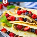 These Nutella crepes are a foolproof recipe for blender crepes filled with Nutella and fresh berries and served with whipped cream.