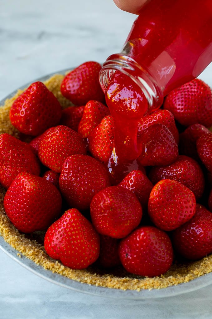 No Bake Strawberry Pie Recipe | Fresh Strawberry Pie | Strawberry Pie Recipe | No Bake Pie Recipe #strawberry #strawberrypie #nobake #nobakepie #dessert #edsug Glaze being poured over a strawberry pie.