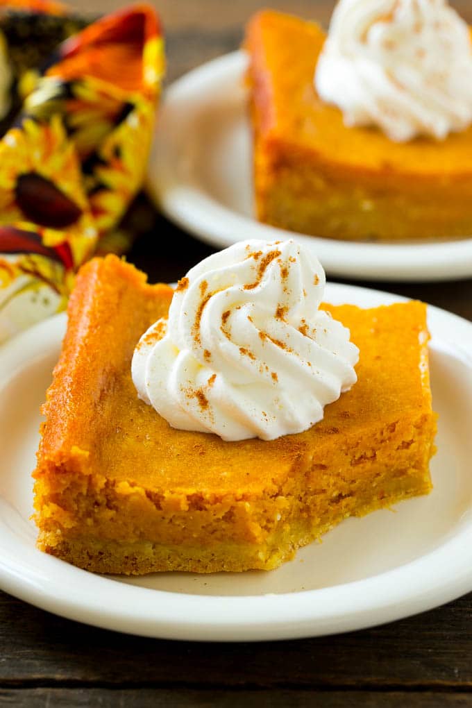 Pumpkin Gooey Butter Cake Recipe | Pumpkin Cake Recipe | Gooey Butter Cake | Pumpkin Dessert | Thanksgiving Dessert #pumpkin #cake #pumpkincake #gooeybuttercake #dessert #edsug A slice of pumpkin butter cake with a bite taken out of it.