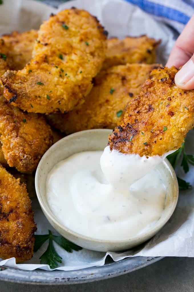 Baked Fried Chicken Recipe | Oven Fried Chicken | Baked Chicken Fingers | Crispy Chicken Fingers #chicken #friedchicken #bakedchicken #ovenfriedchicken #chickenfingers #dinner #edsug A chicken finger being dipped into ranch dressing.