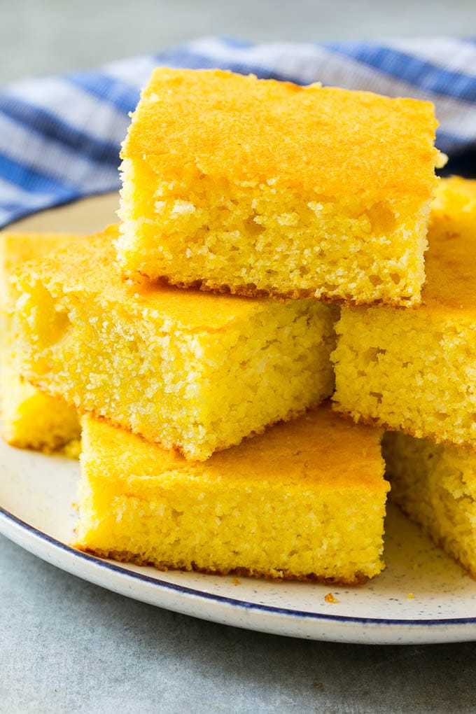 Honey Cornbread Recipe | Buttermilk Cornbread | Easy Cornbread | Homemade Cornbread | Cast Iron Cornbread #cornbread #honey #buttermilk #bread #edsug A plate full of squares of bread made with cornmeal.