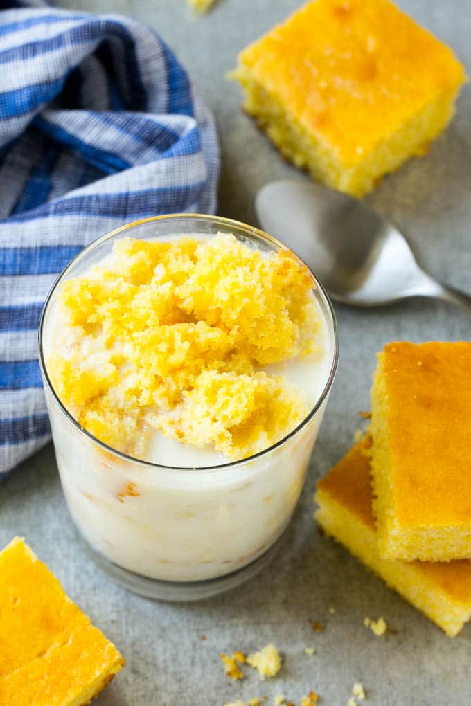 Honey Cornbread Recipe | Buttermilk Cornbread | Easy Cornbread | Homemade Cornbread | Cast Iron Cornbread #cornbread #honey #buttermilk #bread #edsug A glass of milk with cornbread crumbled into it.